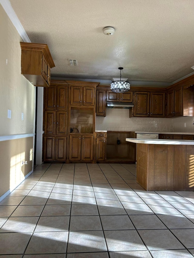 kitchen with visible vents, ornamental molding, under cabinet range hood, light tile patterned floors, and decorative backsplash