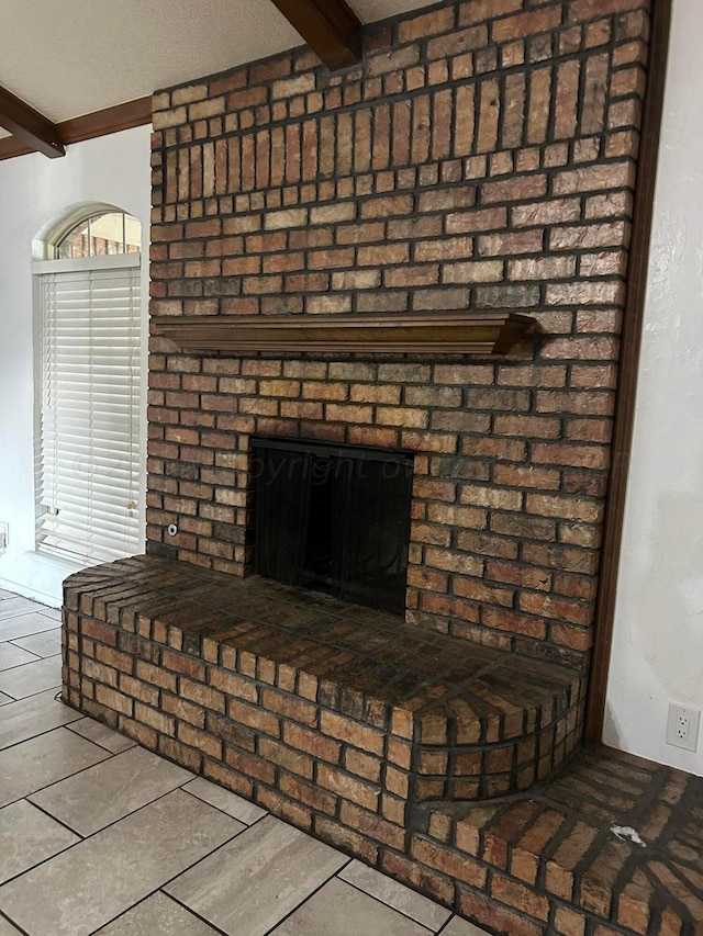 details featuring beam ceiling and a brick fireplace