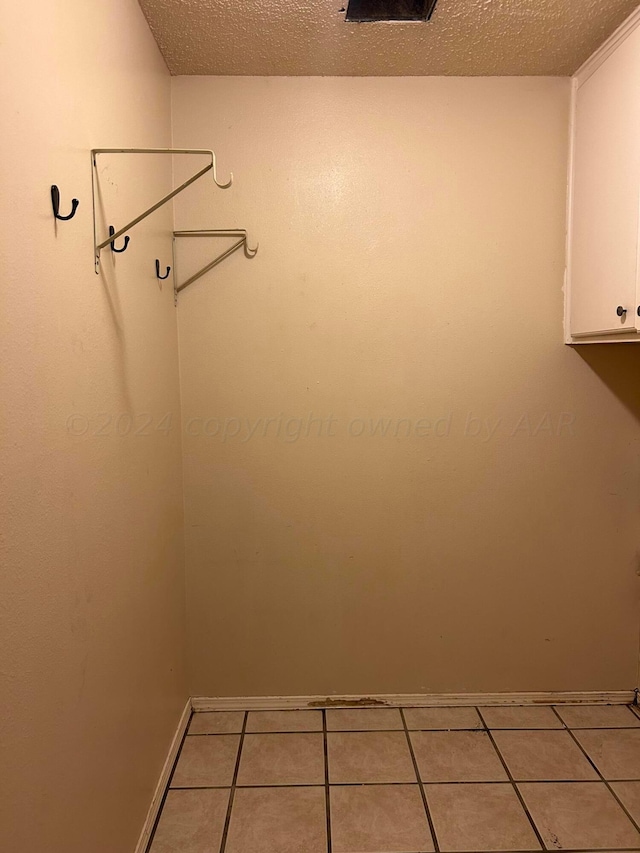 laundry room with light tile patterned floors and a textured ceiling