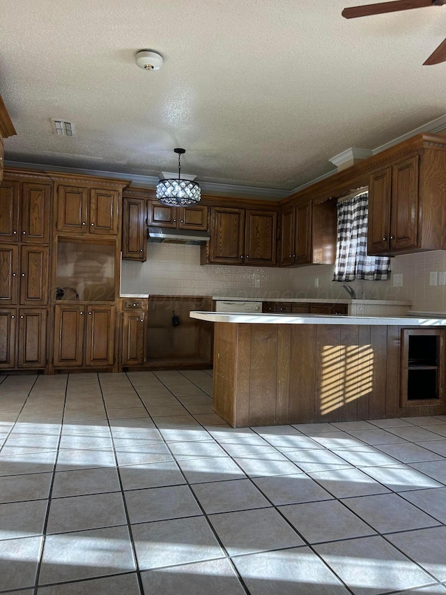 kitchen featuring light tile patterned floors, visible vents, ornamental molding, and decorative backsplash