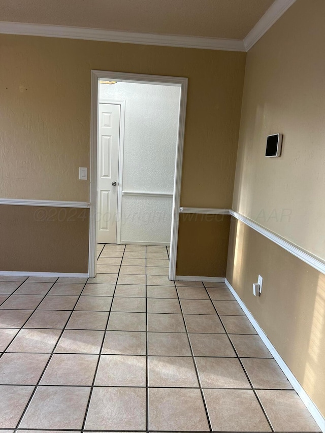 unfurnished room featuring crown molding, light tile patterned floors, and baseboards