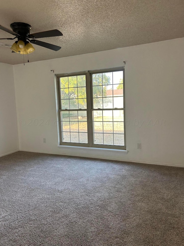 spare room featuring a textured ceiling, carpet, and a ceiling fan