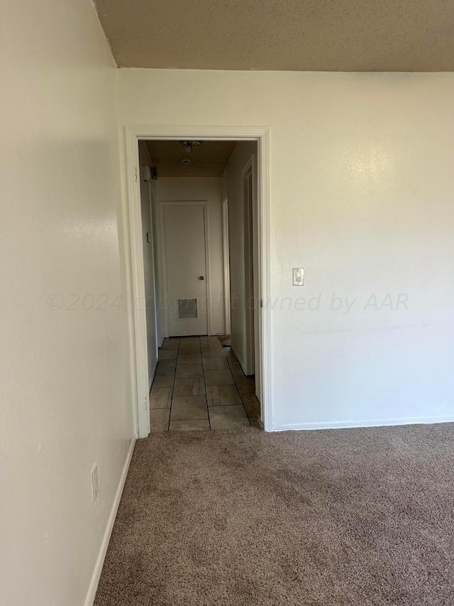 corridor with visible vents, baseboards, and carpet