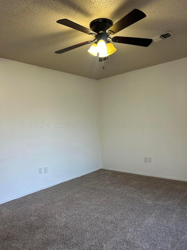 carpeted empty room featuring ceiling fan, baseboards, visible vents, and a textured ceiling