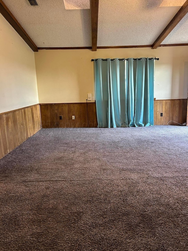 2914 Detroit St, Amarillo, TX 79103 - spare room featuring wooden walls, wainscoting, carpet, a textured ceiling, and beamed ceiling