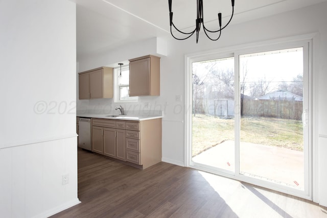 kitchen with dark hardwood / wood-style floors, dishwasher, sink, backsplash, and a chandelier