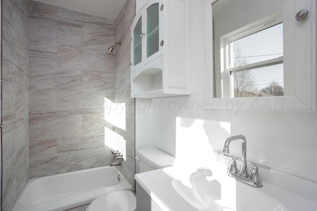 full bathroom with vanity, tiled shower / bath combo, and toilet