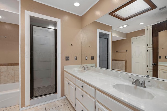 bathroom featuring a garden tub, a sink, tile patterned floors, and double vanity