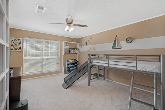 bedroom featuring carpet flooring, a textured ceiling, visible vents, and ornamental molding