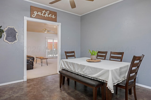 carpeted dining room featuring baseboards, ornamental molding, finished concrete floors, and ceiling fan