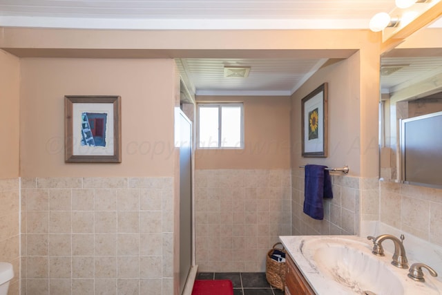 233 Doucette Dr, Howardwick, TX 79226 - bathroom featuring tile walls, vanity, a shower stall, a wainscoted wall, and tile patterned floors