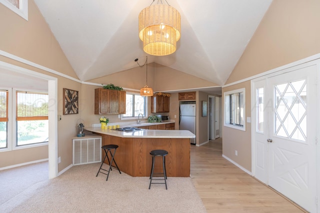 233 Doucette Dr, Howardwick, TX 79226 - kitchen with freestanding refrigerator, a peninsula, vaulted ceiling, light countertops, and a breakfast bar