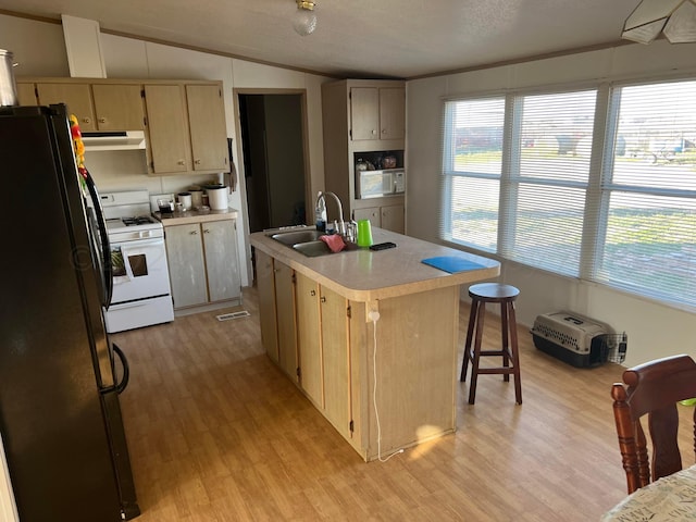 kitchen featuring lofted ceiling, a center island with sink, sink, light brown cabinets, and white appliances