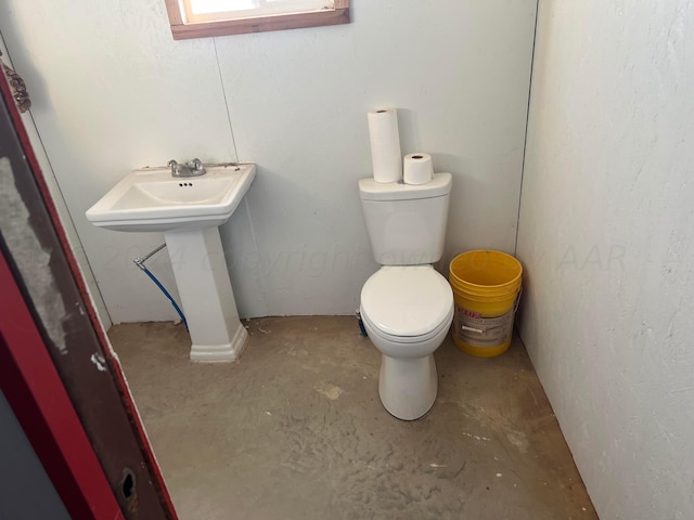 bathroom featuring toilet and concrete floors