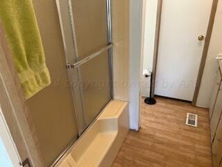 bathroom featuring hardwood / wood-style floors and an enclosed shower