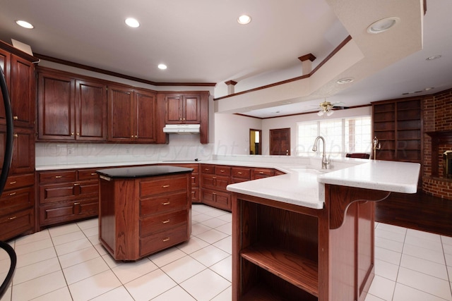 4502 Chesapeake Pl, Amarillo, TX 79119 - kitchen with under cabinet range hood, a kitchen island, a sink, light tile patterned floors, and recessed lighting
