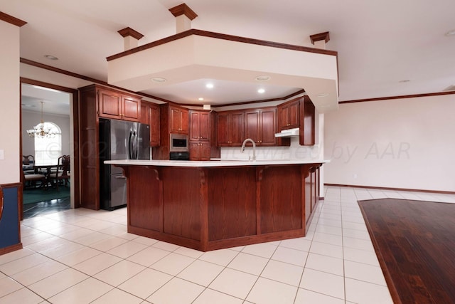 4502 Chesapeake Pl, Amarillo, TX 79119 - kitchen featuring freestanding refrigerator, light countertops, built in microwave, a breakfast bar, and crown molding