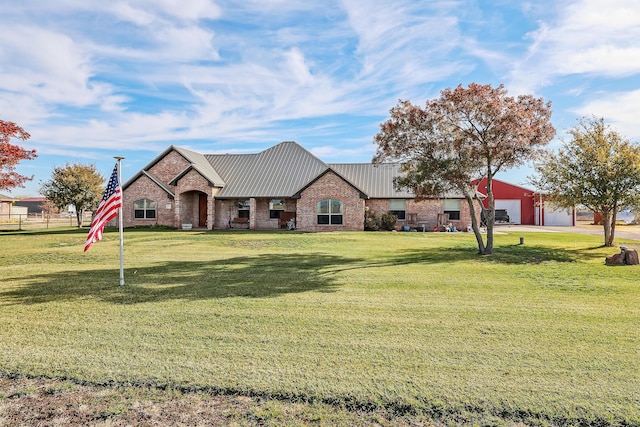 view of front of house with metal roof, a front yard, stone siding, and brick siding
