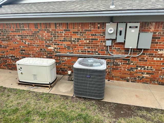 107 Galahad St, Borger, TX 79007 - exterior view of central AC unit, a power unit, a shingled roof, electric meter, and brick siding