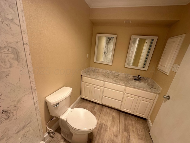 107 Galahad St, Borger, TX 79007 - full bathroom featuring toilet, vanity, wood finished floors, ornamental molding, and baseboards