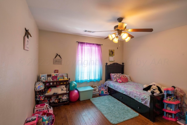 bedroom with visible vents, a ceiling fan, and wood finished floors