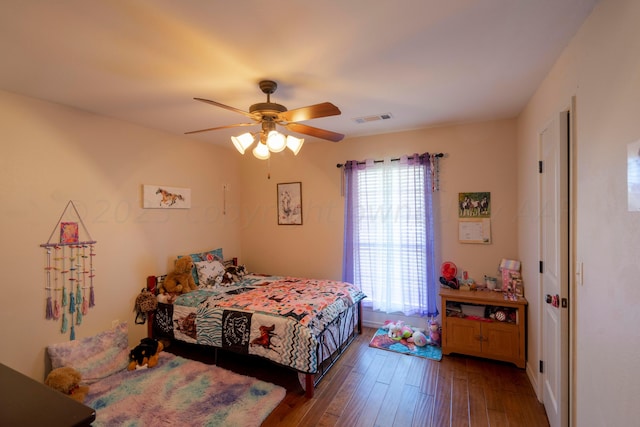 bedroom with visible vents, a ceiling fan, and hardwood / wood-style flooring