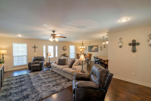 living area with baseboards, a ceiling fan, a healthy amount of sunlight, and crown molding