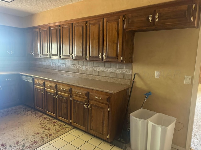 801 Skyline Dr, Borger, TX 79007 - kitchen featuring dishwashing machine, backsplash, light countertops, light tile patterned floors, and a textured ceiling