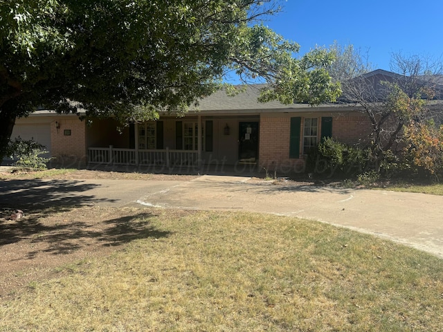 801 Skyline Dr, Borger, TX 79007 - ranch-style home featuring a porch, brick siding, a front yard, an attached garage, and driveway