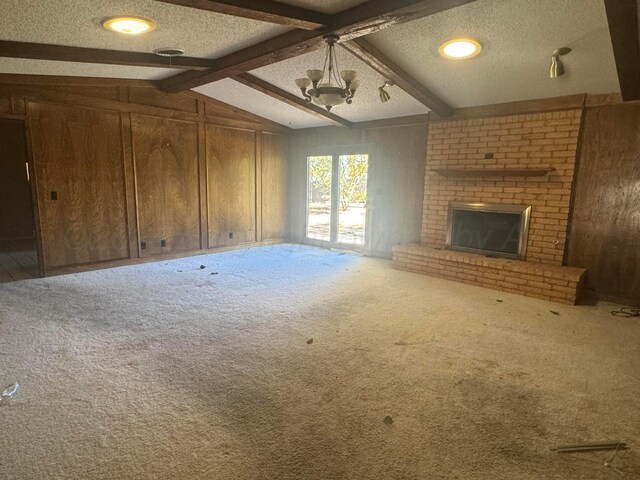 801 Skyline Dr, Borger, TX 79007 - unfurnished living room with wooden walls, carpet floors, a textured ceiling, a brick fireplace, and a chandelier