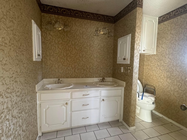 801 Skyline Dr, Borger, TX 79007 - full bathroom with tile patterned floors, toilet, wallpapered walls, double vanity, and a textured ceiling