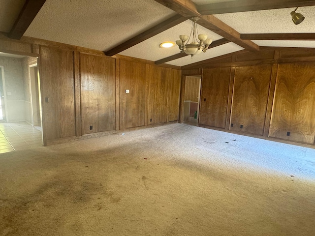 801 Skyline Dr, Borger, TX 79007 - unfurnished room featuring wood walls, light colored carpet, a chandelier, and a textured ceiling