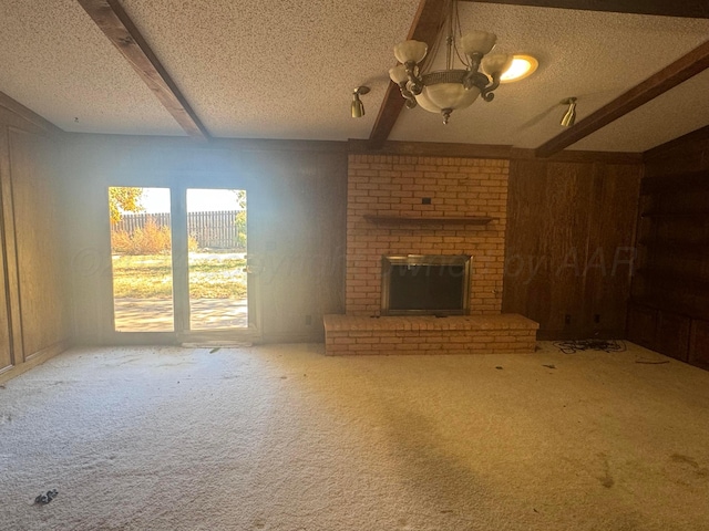 801 Skyline Dr, Borger, TX 79007 - unfurnished living room with a chandelier, carpet, beam ceiling, a textured ceiling, and a fireplace