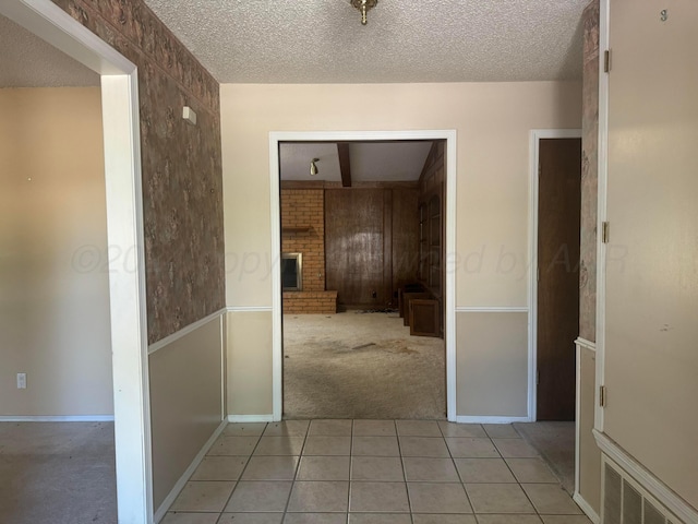 801 Skyline Dr, Borger, TX 79007 - hall with light colored carpet, a textured ceiling, and light tile patterned flooring