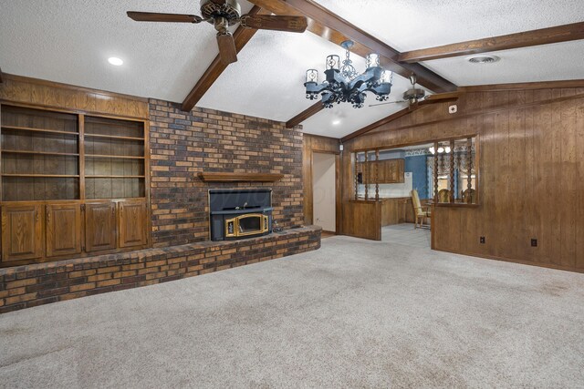 6814 Blacksmith Ln, Amarillo, TX 79109 - unfurnished living room with a textured ceiling, wood walls, carpet floors, a ceiling fan, and a wood stove