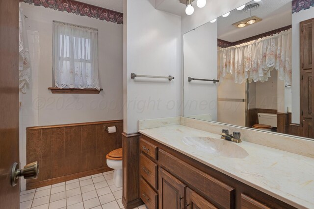 6814 Blacksmith Ln, Amarillo, TX 79109 - full bathroom featuring a wainscoted wall, vanity, tile patterned floors, and curtained shower