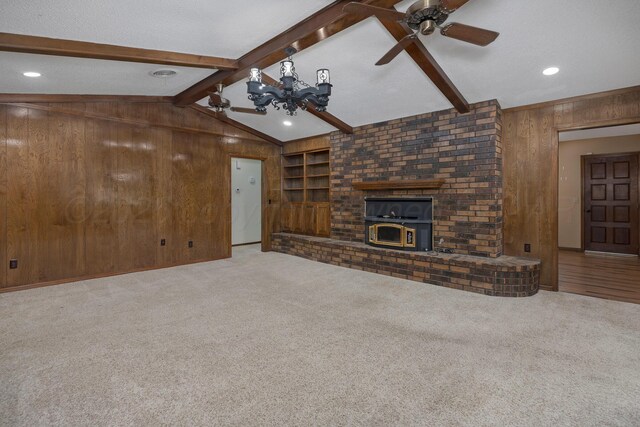 6814 Blacksmith Ln, Amarillo, TX 79109 - unfurnished living room featuring wood walls, a wood stove, carpet flooring, a chandelier, and ceiling fan