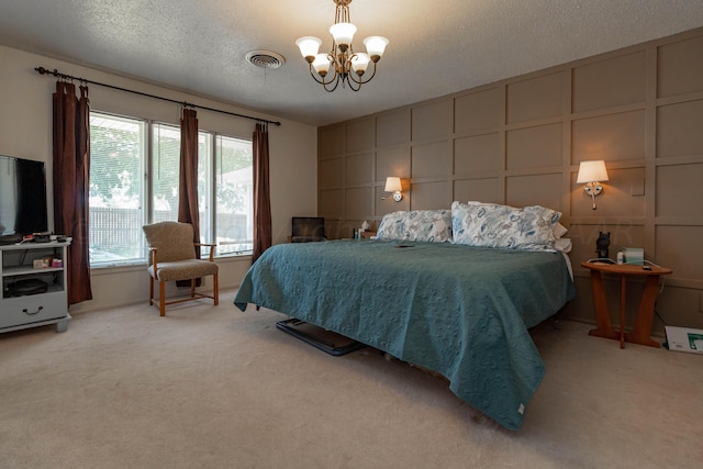 carpeted bedroom with an inviting chandelier and a textured ceiling