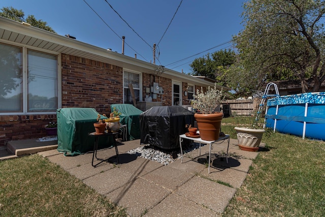 view of patio / terrace with a fenced in pool and a grill