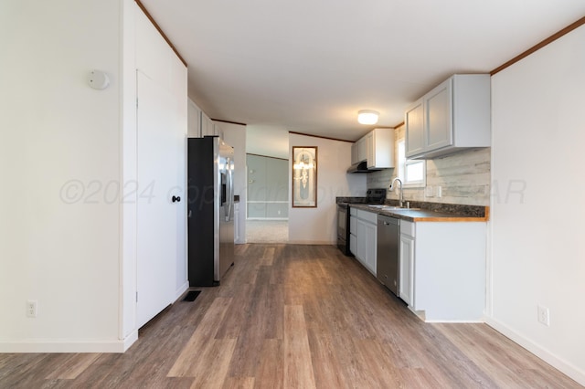 kitchen featuring white cabinetry, hardwood / wood-style flooring, sink, and appliances with stainless steel finishes