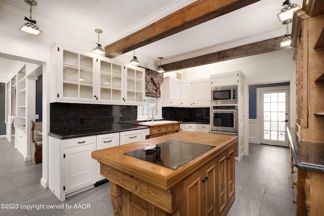 2802 S Hughes St, Amarillo, TX 79109 - kitchen featuring appliances with stainless steel finishes, a sink, butcher block countertops, decorative backsplash, and ornamental molding