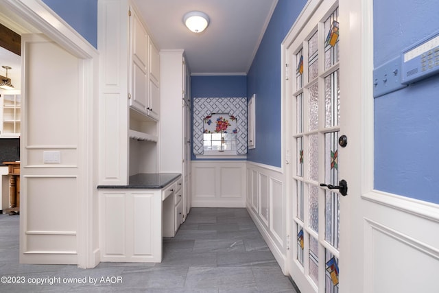 2802 S Hughes St, Amarillo, TX 79109 - mudroom featuring a decorative wall, crown molding, and wainscoting