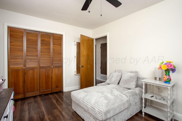 bedroom featuring dark wood-type flooring, a closet, baseboards, and a ceiling fan