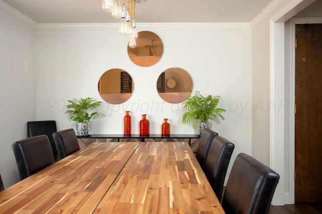 dining area with ornamental molding and wood finished floors