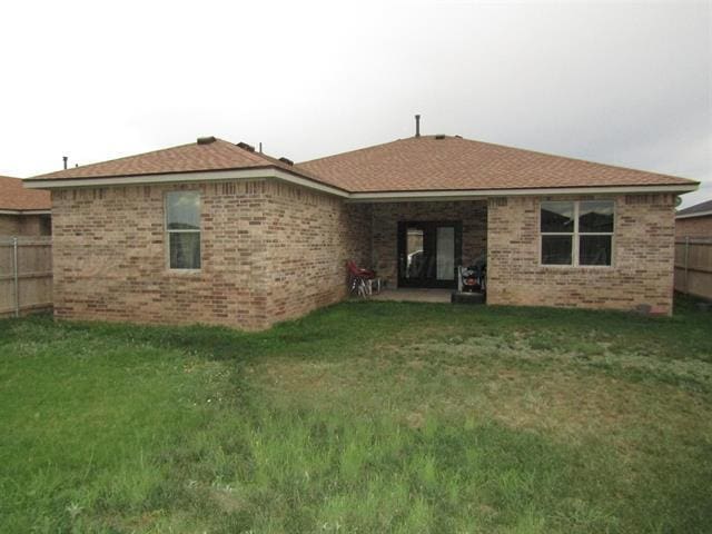 rear view of property with a yard