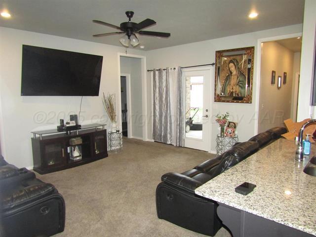 living room with ceiling fan and carpet floors