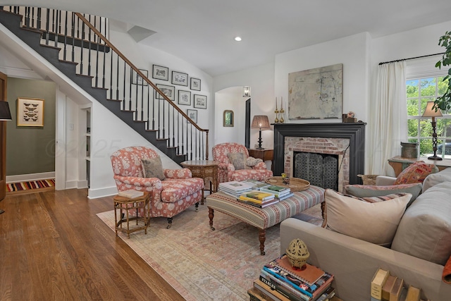 2215 S Hughes St, Amarillo, TX 79109 - living room featuring wood finished floors, stairs, a fireplace, arched walkways, and vaulted ceiling