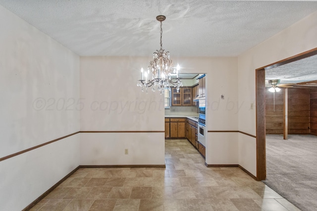 kitchen featuring a textured ceiling, light carpet, decorative light fixtures, and wall oven