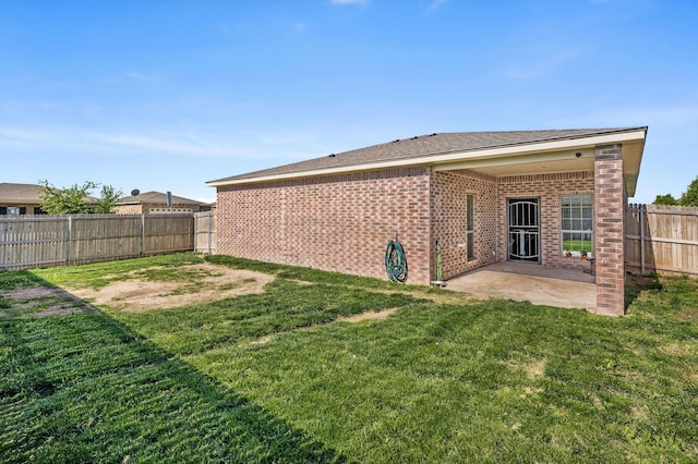 rear view of property with brick siding and a patio