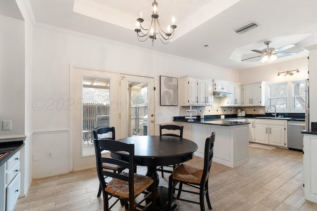 dining room featuring a tray ceiling, wood finish floors, plenty of natural light, and visible vents